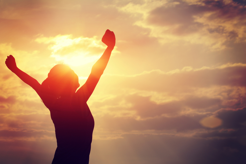 strong confident woman open arms to sunrise at sea